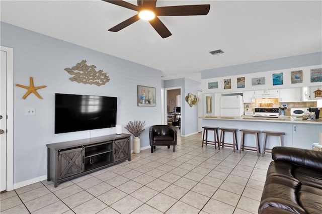 living room featuring light tile patterned floors and ceiling fan