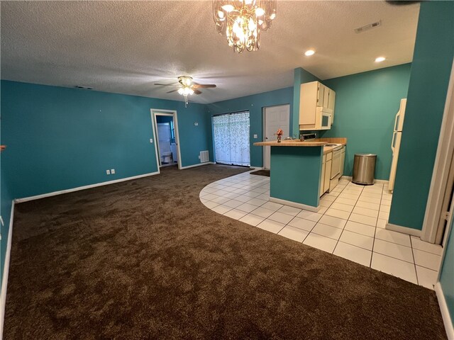 kitchen with light colored carpet, white cabinets, a textured ceiling, ceiling fan, and a breakfast bar