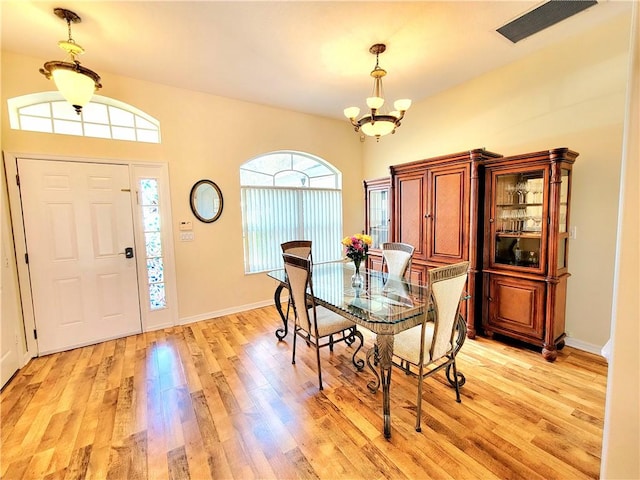 dining space with a notable chandelier and light wood-type flooring