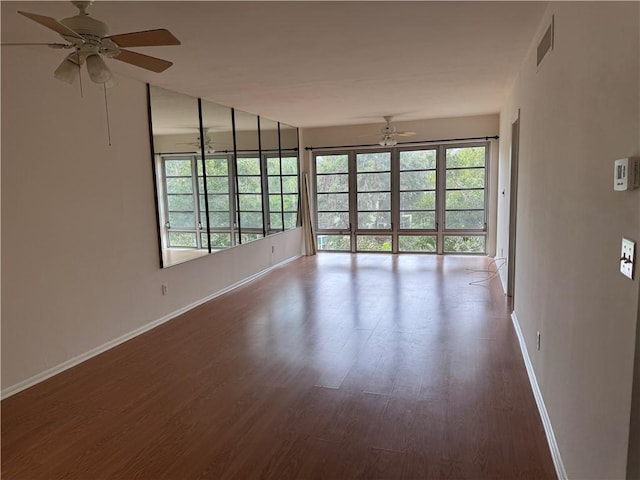 unfurnished room with visible vents, ceiling fan, baseboards, and wood finished floors