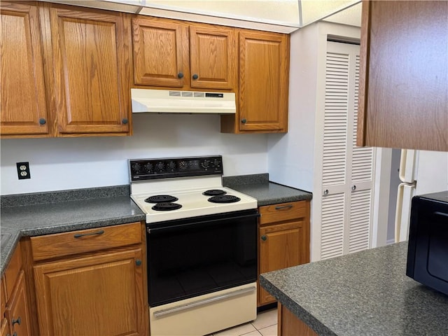 kitchen featuring under cabinet range hood, electric range, brown cabinetry, and dark countertops