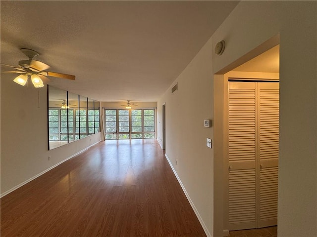 empty room with visible vents, wood finished floors, baseboards, and a textured ceiling