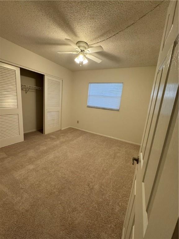 unfurnished bedroom featuring a closet, a textured ceiling, and carpet