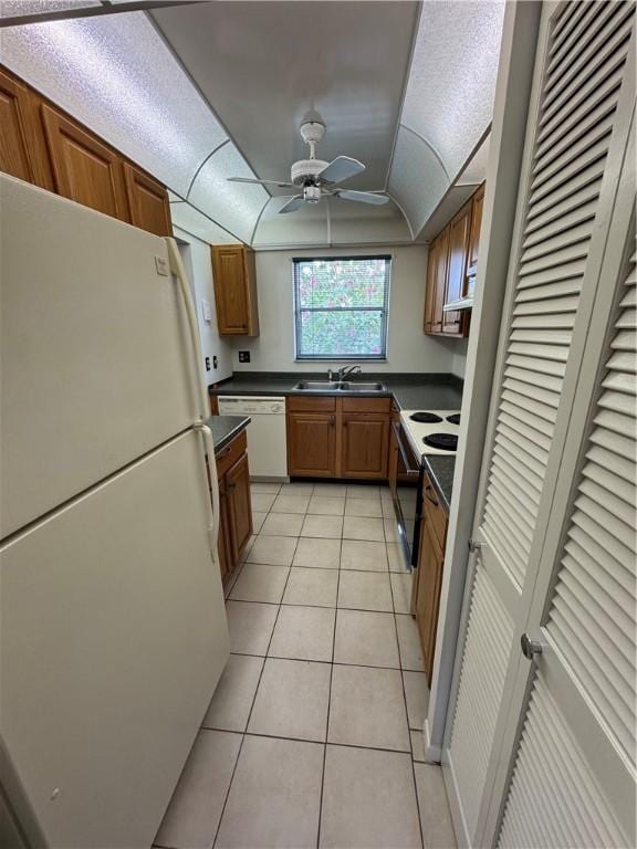 kitchen featuring ceiling fan, white appliances, sink, and light tile patterned floors