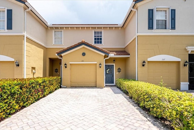 263 Provence Pl, Vero Beach, FL 32960 - townhome / multi-family property featuring a garage, stucco siding, decorative driveway, and a tiled roof