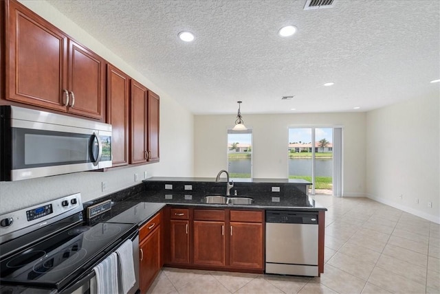 263 Provence Pl, Vero Beach, FL 32960 - kitchen featuring stainless steel appliances, a peninsula, a textured ceiling, light tile patterned floors, and dark stone countertops