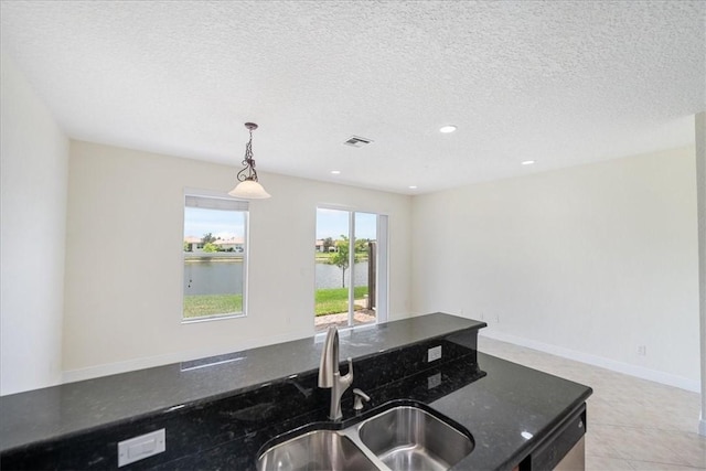 263 Provence Pl, Vero Beach, FL 32960 - kitchen with pendant lighting, dishwasher, dark stone counters, open floor plan, and a textured ceiling