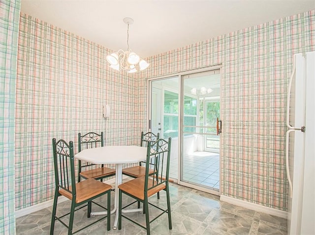 dining area with baseboards, a notable chandelier, and wallpapered walls