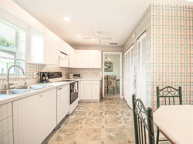 kitchen featuring light countertops, white dishwasher, a sink, and under cabinet range hood