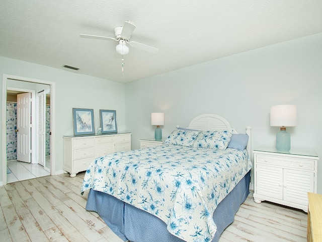 bedroom featuring a textured ceiling, visible vents, and wood finished floors