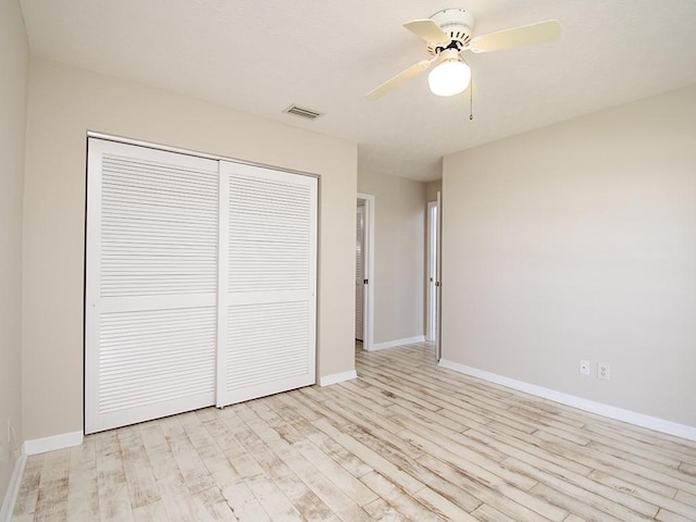 unfurnished bedroom with light wood-style floors, a closet, visible vents, and baseboards