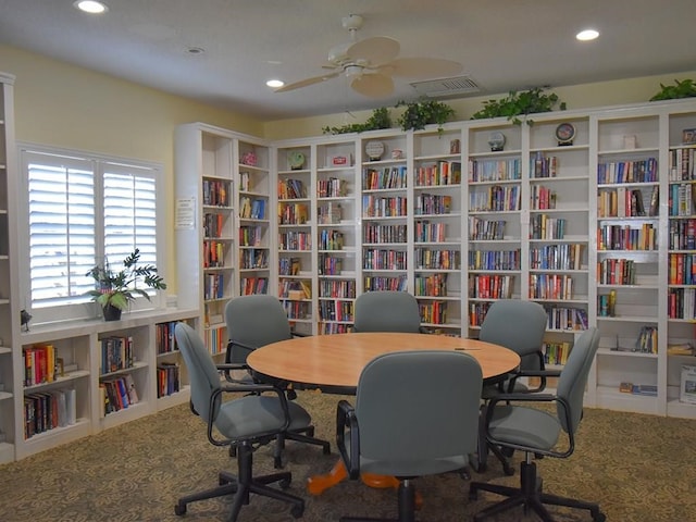 carpeted home office with recessed lighting, visible vents, ceiling fan, and wall of books