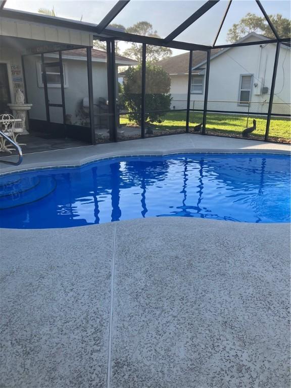 pool with a lanai and a patio area