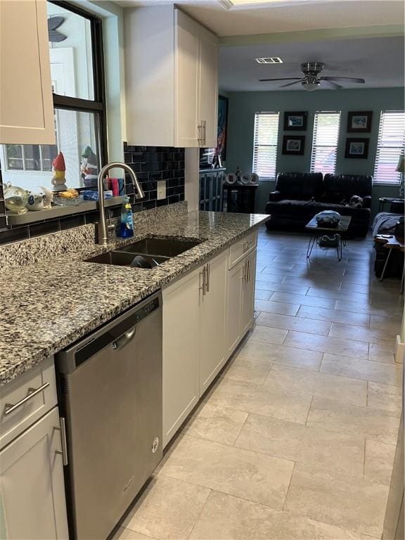 kitchen featuring ceiling fan, a sink, dishwasher, open floor plan, and backsplash