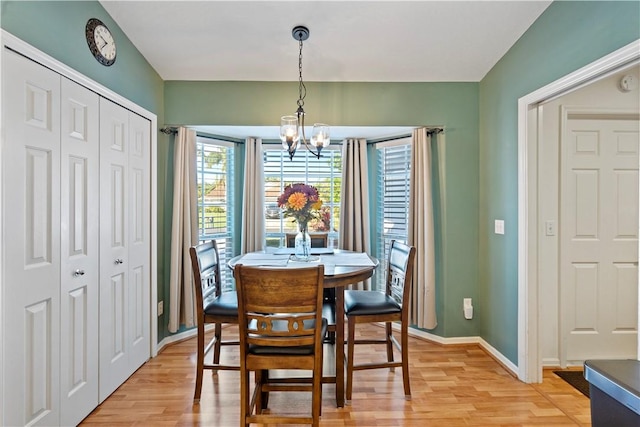 dining room with an inviting chandelier, baseboards, and light wood finished floors