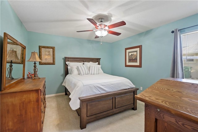 bedroom featuring baseboards, light carpet, and a ceiling fan