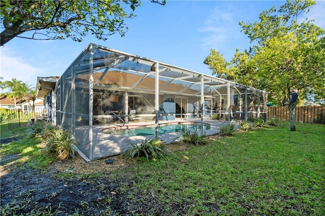 back of house featuring a fenced in pool, a lawn, a lanai, and fence