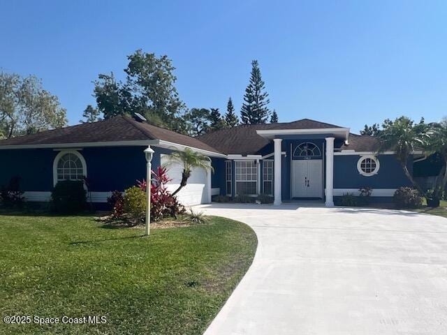 ranch-style house with an attached garage, driveway, and a front lawn