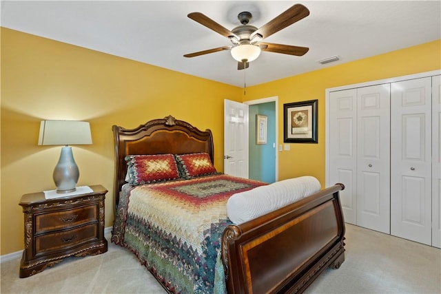 carpeted bedroom featuring a closet, visible vents, baseboards, and ceiling fan