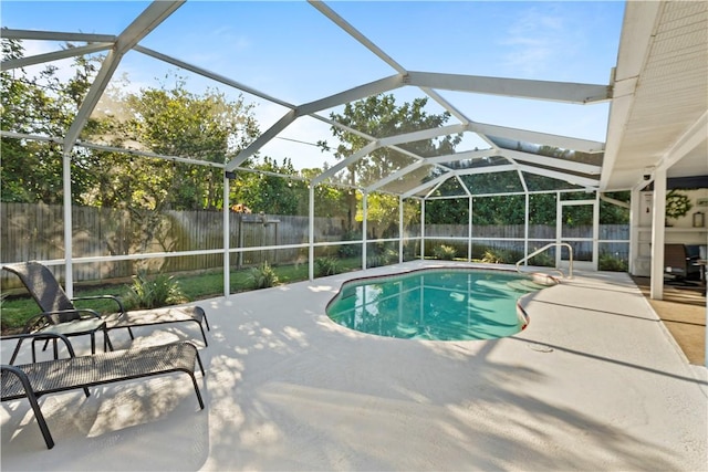 view of swimming pool with a patio area, a fenced in pool, glass enclosure, and a fenced backyard