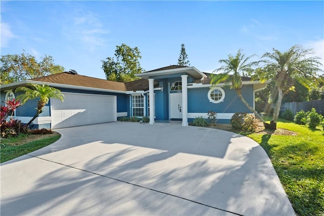 view of front facade with stucco siding, an attached garage, concrete driveway, and fence