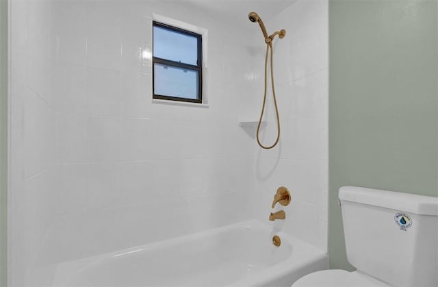 bathroom with toilet and tiled shower / bath