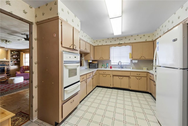 kitchen with ceiling fan, light brown cabinets, sink, and white appliances