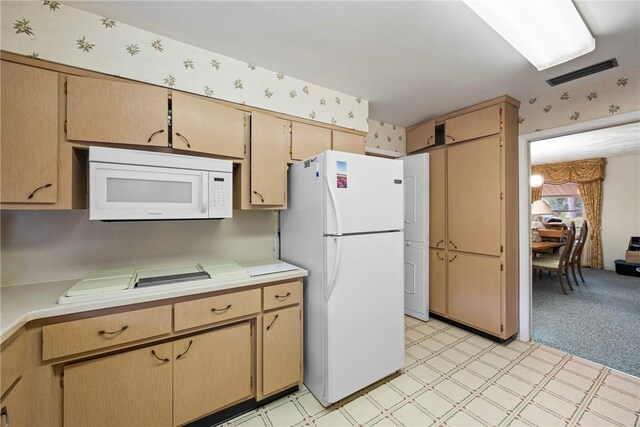 kitchen featuring light colored carpet, light brown cabinets, and white appliances