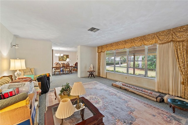 living room featuring a notable chandelier and carpet flooring