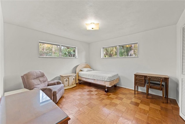 bedroom with light parquet flooring and multiple windows