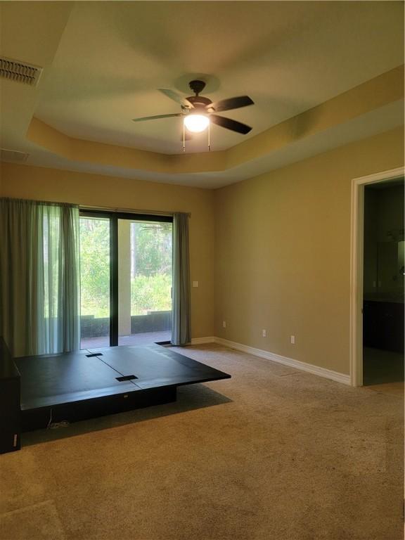 4295 55th St, Vero Beach, FL 32967 - carpeted spare room with ceiling fan, baseboards, and a tray ceiling