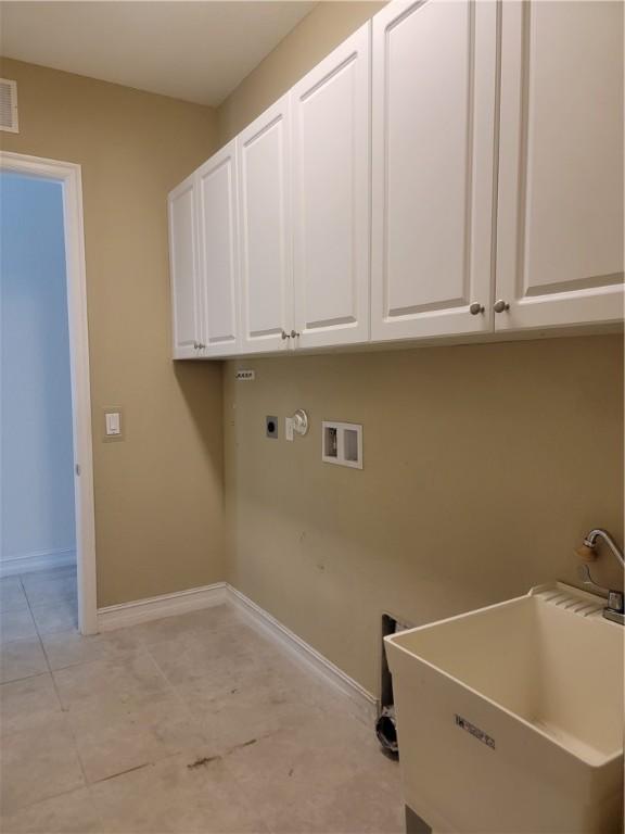 4295 55th St, Vero Beach, FL 32967 - washroom with cabinet space, baseboards, washer hookup, electric dryer hookup, and light tile patterned flooring