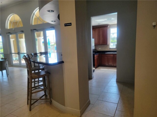 4295 55th St, Vero Beach, FL 32967 - kitchen featuring a kitchen bar, baseboards, dark countertops, and crown molding