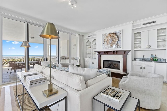 living room featuring a wealth of natural light, crown molding, and a notable chandelier