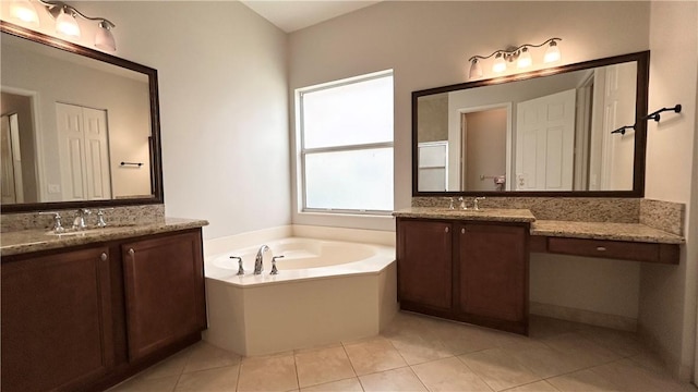 bathroom with tile patterned flooring, vanity, and a bath