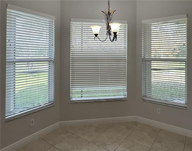 unfurnished dining area featuring light tile patterned floors and a notable chandelier