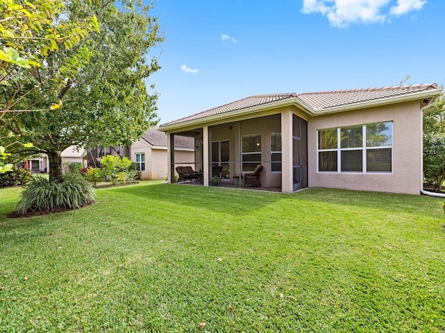 rear view of property featuring a yard and a sunroom