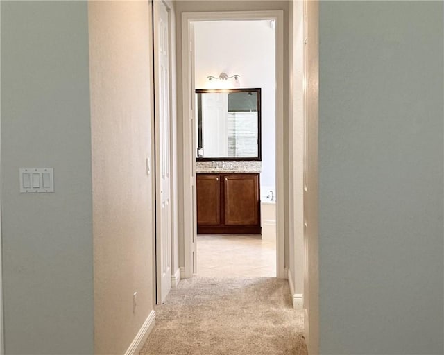 hallway featuring light colored carpet