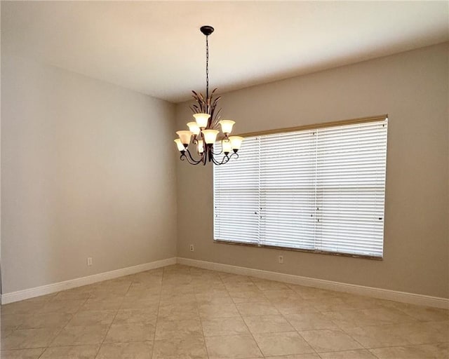 spare room featuring a chandelier