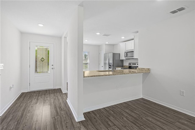 7724 104th Ave, Vero Beach, FL 32967 - kitchen featuring stainless steel appliances, dark wood-style floors, white cabinetry, healthy amount of natural light, and recessed lighting