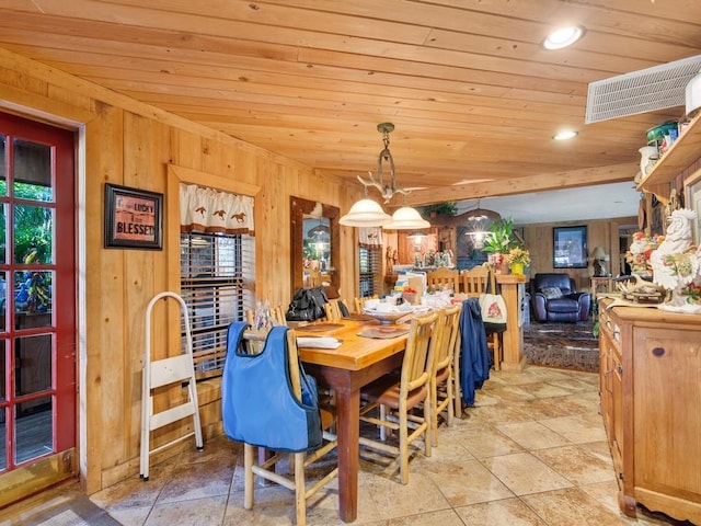 dining space with wood walls and wooden ceiling