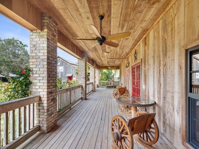 wooden terrace with a porch and ceiling fan