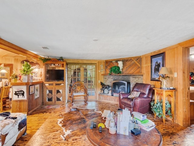 living room featuring a brick fireplace, hardwood / wood-style flooring, and wooden walls