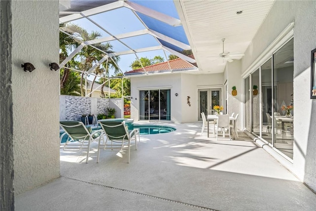 view of patio featuring a fenced in pool, ceiling fan, and glass enclosure