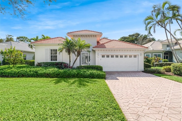 mediterranean / spanish-style home featuring a garage and a front lawn