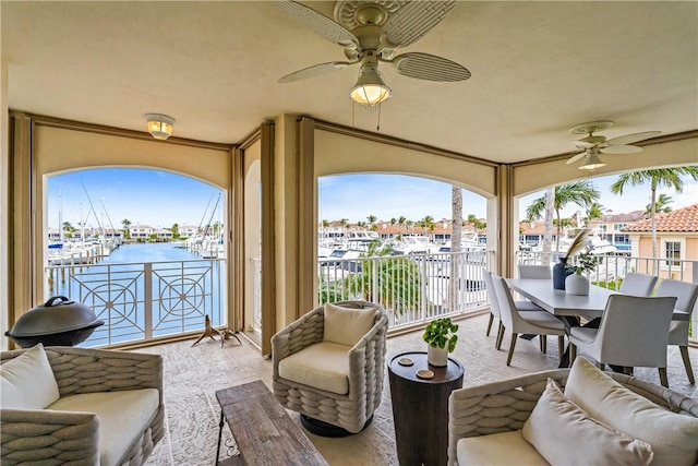 interior space with ceiling fan and a water view