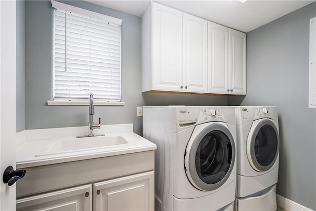 clothes washing area featuring cabinets, separate washer and dryer, and sink