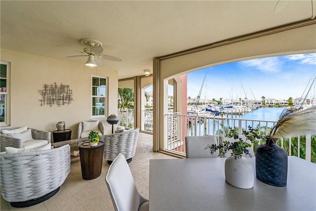 sunroom with a water view and ceiling fan