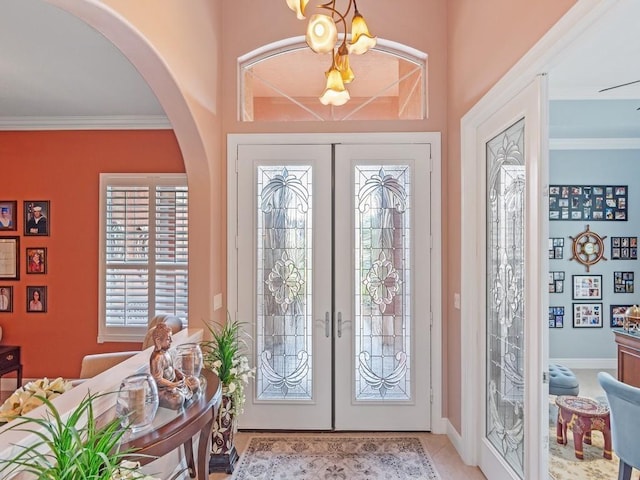 4335 65th Dr, Vero Beach, FL 32967 - tiled foyer entrance featuring french doors, arched walkways, plenty of natural light, and crown molding