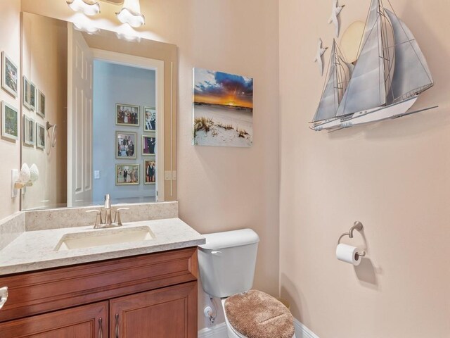 4335 65th Dr, Vero Beach, FL 32967 - half bathroom featuring vanity, toilet, and baseboards